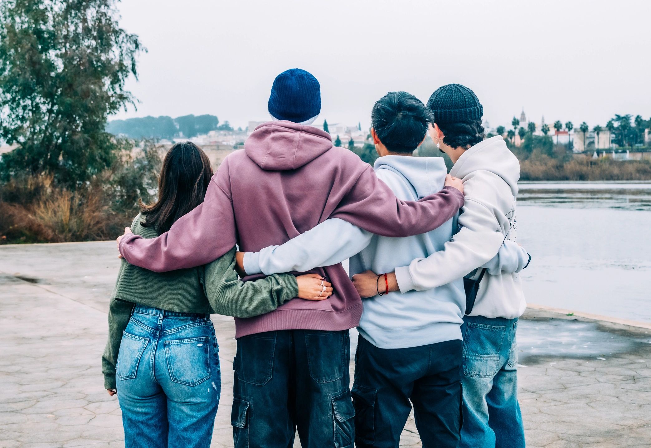 Young people outdoors together by a river, representing connection and shared growth